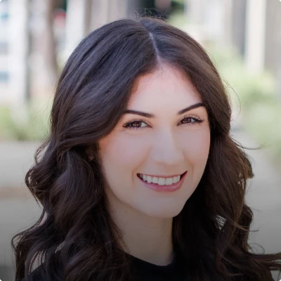 HOA attorney / HOA law A woman with long dark hair and a black shirt smiling at the camera, likely an attorney or lawyer