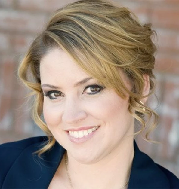 HOA attorney / HOA law A woman with blonde hair and a black blazer smiling at the camera